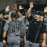 Arizona Diamondbacks' Yasmany Tomas high-fives his way through the dugout after scoring against the San Diego Padres during the second inning of a baseball game Friday, Aug. 19, 2016, in San Diego. (AP Photo/Lenny Ignelzi)