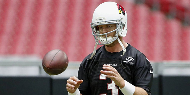 Arizona Cardinals' Carson Palmer reaches out to catch the football as he warms up during practice a...