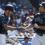 San Diego Padres' Brett Wallace, right, is congratulated by Adam Rosales while scoring against the Arizona Diamondbacks in the sixth inning of a baseball game Sunday, Aug. 21, 2016, in San Diego. (AP Photo/Lenny Ignelzi)