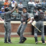 Arizona Diamondbacks' Michael Bourn (1), Jake Lamb (22) and Brandon Drury (27) high-five at home plate after Bourn and Lamb scored on an RBI by Chris Owings off of New York Mets relief pitcher Jonathon Niese in the sixth inning of a baseball game, Thursday, Aug. 11, 2016, in New York. (AP Photo/Kathy Kmonicek)