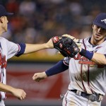 Atlanta Braves' Matt Wisler, left, slaps gloves with Dansby Swanson, right, after Swanson made a long throw from deep shortstop to get Arizona Diamondbacks' Mitch Haniger out at first base during the fourth inning of a baseball game Thursday, Aug. 25, 2016, in Phoenix. (AP Photo/Ross D. Franklin)