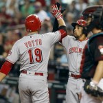 Cincinnati Reds' Joey Votto (19) is congratulated by teammate Billy Hamilton, center, after hitting a two-run home run as Arizona Diamondbacks catcher Tuffy Gosewisch looks on during the first inning of a baseball game, Saturday, Aug. 27, 2016, in Phoenix. (AP Photo/Ralph Freso)