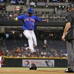 New York Mets' Jose Reyes (7) leaps over a catcher's helmet to score a run on a wild pitch as Mets' James Loney, right, umpire Chad Fairchild, second from right, and Arizona Diamondbacks' Brandon Drury, left, all watch during the first inning of a baseball game Wednesday, Aug. 17, 2016, in Phoenix. (AP Photo/Ross D. Franklin)