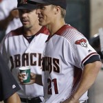 Arizona Diamondbacks' Zack Greinke (21) talks with teammates in the dugout, including Tuffy Gosewisch, left, after Greinke recorded his fifth strikeout against the Atlanta Braves, during the fourth inning of a baseball game Wednesday, Aug. 24, 2016, in Phoenix. It was Greinke's 2,000th career strikeout. (AP Photo/Ross D. Franklin)