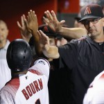 Arizona Diamondbacks' Michael Bourn, left, gets high-fives from teammates and coaches, including assistant hitting coach Mark Grace, right, after Bourn scored a run against the Atlanta Braves during the first inning of a baseball game Wednesday, Aug. 24, 2016, in Phoenix. (AP Photo/Ross D. Franklin)