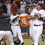 Arizona Diamondbacks' Paul Goldschmidt arrives at home plate as the team celebrates his walk off home run against the Atlanta Braves during the ninth inning of a baseball game Monday, Aug. 22, 2016, in Phoenix. The Diamondbacks defeated the Braves 9-8. (AP Photo/Ross D. Franklin)