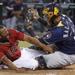 Milwaukee Brewers' Martin Maldonado, right, tags out Arizona Diamondbacks' Michael Bourn, left, trying to score during the first inning of a baseball game, Sunday, Aug. 7, 2016, in Phoenix. (AP Photo/Ross D. Franklin)