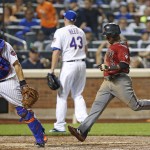 New York Mets catcher Travis d'Arnaud, left, waits for the throw as Arizona Diamondbacks' Jean Segura (2) scores on Paul Goldschmidt's eighth-inning sacrifice fly in a baseball game Wednesday, Aug. 10, 2016, in New York. Mets relief pitcher Addison Reed (43) heads to back up the play. (AP Photo/Kathy Willens)
