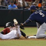 Milwaukee Brewers' Jonathan Villar (5) tags out Arizona Diamondbacks' Archie Bradley (25) after Bradley was caught too far off of third base during the fourth inning of a baseball game, Sunday, Aug. 7, 2016, in Phoenix. (AP Photo/Ross D. Franklin)