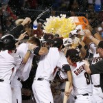 Arizona Diamondbacks players surround Paul Goldschmidt after his walk off home run against the Atlanta Braves during the ninth inning of a baseball game Monday, Aug. 22, 2016, in Phoenix. The Diamondbacks defeated the Braves 9-8. (AP Photo/Ross D. Franklin)
