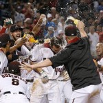 After hitting a walk off home run, Arizona Diamondbacks' Paul Goldschmidt (44) is met at home plate by teammates, including Tuffy Gosewisch (8) and Yasmany Tomas (24), during the ninth inning of a baseball game against the Atlanta Braves Monday, Aug. 22, 2016, in Phoenix. The Diamondbacks defeated the Braves 9-8. (AP Photo/Ross D. Franklin)