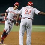 Cincinnati Reds' Joey Votto (19) is congratulated by third base coach Billy Hatcher as he rounds the base after hitting a two-run home run against the Arizona Diamondbacks during the first inning of a baseball game, Saturday, Aug. 27, 2016, in Phoenix. (AP Photo/Ralph Freso)