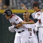 Arizona Diamondbacks' Brandon Drury, left, drips with Gatorade as he celebrates his game-winning sacrifice fly against the Atlanta Braves with a bat boy, right, and Jean Segura (2) in the 11th inning of a baseball game Wednesday, Aug. 24, 2016, in Phoenix. The Diamondbacks defeated the Braves 10-9. (AP Photo/Ross D. Franklin)
