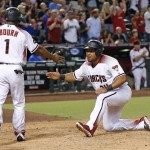 Arizona Diamondbacks' Yasmany Tomas, right, slaps hands with Michael Bourn (1) after both scored on a three-run double hit by Welington Castillo against the Atlanta Braves during the seventh inning of a baseball game Monday, Aug. 22, 2016, in Phoenix. (AP Photo/Ross D. Franklin)
