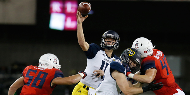 Northern Arizona quarterback Case Cookus (15) throws against Arizona during the first half of an NC...