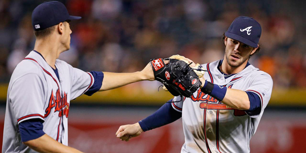 Atlanta Braves' Matt Wisler, left, slaps gloves with Dansby Swanson, right, after Swanson made a lo...