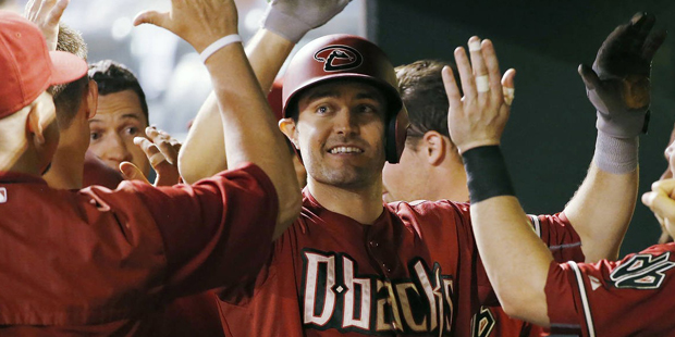 Arizona Diamondbacks' A.J. Pollock is congratulated by teammates in the dugout  after hitting a two...