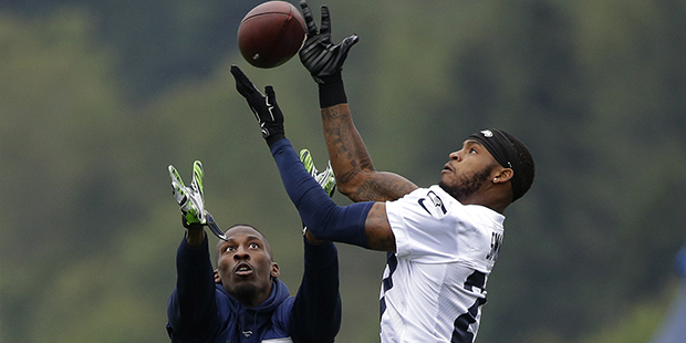 Seattle Seahawks cornerback Tharold Simon, right, deflects a pass intended for wide receiver Dougla...