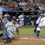 San Francisco Giants' Hunter Pence, second from left, scores a run on a sacrifice fly as he beats a late tag by Arizona Diamondbacks' Welington Castillo, right, as umpire Dale Scott, left, watches during the second inning of a baseball game Friday, Sept. 9, 2016, in Phoenix. (AP Photo/Ross D. Franklin)