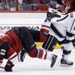 Los Angeles Kings' Sean Backman (61) sends Arizona Coyotes' Conor Garland (83) to the ice with a check during the first period of a preseason NHL hockey game Monday, Sept. 26, 2016, in Glendale, Ariz. (AP Photo/Ross D. Franklin)