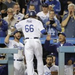 Los Angeles Dodgers' Yasiel Puig, center, is congratulated by Charlie Culberson, left, and manager Dave Roberts after hitting a home run during the sixth inning of a baseball game against the Arizona Diamondbacks, Wednesday, Sept. 7, 2016, in Los Angeles. (AP Photo/Jae C. Hong)