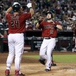 Arizona Diamondbacks' Chris Owings (16) is congratulated by teammate Yasmany Tomas as he scores against the San Francisco Giants on single by Welington Castillo during the fifth inning of a baseball game, Sunday, Sept. 11, 2016, in Phoenix. (AP Photo/Ralph Freso)