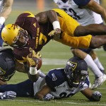 Arizona State's Kalen Ballage (7) gets upended by Northern Arizona's Jake Casteel (11) and Maurice Davison, bottom right, during the first half of an NCAA college football game Saturday, Sept. 3, 2016, in Tempe, Ariz. (AP Photo/Ross D. Franklin)