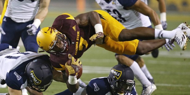 Arizona State's Kalen Ballage (7) gets upended by Northern Arizona's Jake Casteel (11) and Maurice ...