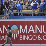 A fan catches the ball on a three-run home run by Los Angeles Dodgers' Corey Seager as Arizona Diamondbacks center fielder Socrates Brito watches during the fifth inning of a baseball game, Monday, Sept. 5, 2016, in Los Angeles. (AP Photo/Mark J. Terrill)
