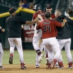 Arizona Diamondbacks' Brandon Drury, center, celebrates with Yasmany Tomas (24) and teammates after his game winning RBI single against the Los Angeles Dodgers during the 12th inning of a baseball game, Sunday, Sept. 18, 2016, in Phoenix. The Diamondbacks defeated the Dodgers 10-9. (AP Photo/Ralph Freso)
