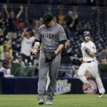 Arizona Diamondbacks relief pitcher Zack Godley, left, tosses the ball after San Diego Padres' Adam Rosales hits a two-run home run as Ryan Schimpf rounds the bases during the sixth inning of a baseball game in San Diego, Tuesday, Sept. 20, 2016. (AP Photo/Chris Carlson)