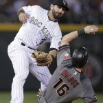 Colorado Rockies shortstop Daniel Descalso, back, applies the tag to put out Arizona Diamondbacks' Chris Owings, who tried to steal second base in the seventh inning of a baseball game Saturday, Sept. 3, 2016, in Denver. Arizona won 9-4. (AP Photo/David Zalubowski)