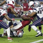 Arizona Cardinals running back David Johnson, center, pushes across the goal line for a touchdown as New England Patriots defensive end Chris Long (95) defends during the second half of an NFL football game, Sunday, Sept. 11, 2016, in Glendale, Ariz. (AP Photo/Rick Scuteri)