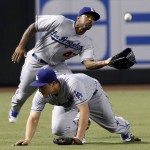 Los Angeles Dodgers shortstop Corey Seager, bottom, drops to his hands and knees as teammate Howie Kendrick charges in to catch a shallow fly ball by Arizona Diamondbacks' Tuffy Gosewisch during the second inning of a baseball game, Sunday, Sept. 18, 2016, in Phoenix. (AP Photo/Ralph Freso)