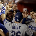 Los Angeles Dodgers' Chase Utley (26) is greeted in the dugout after scoring on a double by Justin Turner during the fifth inning of a baseball game, Thursday, Sept. 15, 2016, in Phoenix. (AP Photo/Matt York)