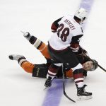 Anaheim Ducks' Ryan Garbutt falls to the ice as he and Arizona Coyotes' Nick Merkley compete for the puck during the third period of an NHL preseason hockey game Tuesday, Sept. 27, 2016, in Anaheim, Calif. The Coyotes won 2-1. (AP Photo/Jae C. Hong)