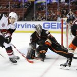 Anaheim Ducks' Cam Fowler, right, moves the puck away from Arizona Coyotes' Dylan Strome, left, in front of Ducks goalie Matthew Hackett during the first period of an NHL preseason hockey game, Tuesday, Sept. 27, 2016, in Anaheim, Calif. (AP Photo/Jae C. Hong)