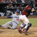 Los Angeles Dodgers' Austin Barnes (15) slides across the plate to score a run on a double by teammate Adrian Gonzales as Arizona Diamondbacks catcher Tuffy Gosewisch fields the throw during the sixth inning of a baseball game, Sunday, Sept. 18, 2016, in Phoenix. (AP Photo/Ralph Freso)