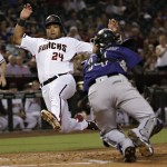 Arizona Diamondbacks' Yasmany Tomas (24) scores on a base hit by teammate Kyle Jensen as Colorado Rockies' Tony Wolters (14) reaches for the tag during the second inning of a baseball game, Monday, Sept. 12, 2016, in Phoenix. (AP Photo/Matt York)