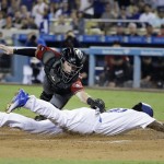 Los Angeles Dodgers' Howie Kendrick, bottom, scores on a double by Corey Seager as Arizona Diamondbacks catcher Chris Herrmann applies a late tag during the first inning of a baseball game, Wednesday, Sept. 7, 2016, in Los Angeles. (AP Photo/Jae C. Hong)
