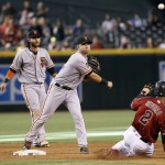San Francisco Giants second baseman Joe Panik, center, throws to first over Arizona Diamondbacks' Jean Segura (2) to complete a double play as teammate Brandon Crawford watches during the seventh inning of a baseball game, Sunday, Sept. 11, 2016, in Phoenix. The Giants defeated the Diamondbacks 5-3. (AP Photo/Ralph Freso)