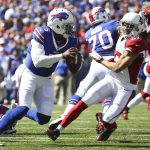 Buffalo Bills quarterback Tyrod Taylor (5) runs under pressure from Arizona Cardinals defensive back Tyvon Branch (27) during the first half of an NFL football game on Sunday, Sept. 25, 2016, in Orchard Park, N.Y. (AP Photo/Bill Wippert)