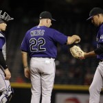 Colorado Rockies manager Walt Weiss (22) hands the baseball to relief pitcher Carlos Estevez (54) as catcher Colorado Rockies Tony Wolters looks on during the seventh inning of a baseball game against the Arizona Diamondbacks, Monday, Sept. 12, 2016, in Phoenix. (AP Photo/Matt York)