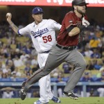 Los Angeles Dodgers relief pitcher Jesse Chavez, left, throws to first base for the out on Arizona Diamondbacks' Mitch Haniger, foreground, during the sixth inning of a baseball game, Wednesday, Sept. 7, 2016, in Los Angeles. (AP Photo/Jae C. Hong)