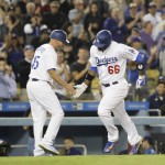 Los Angeles Dodgers' Yasiel Puig, right, celebrates his home run with third base coach Chris Woodward during the sixth inning of a baseball game against the Arizona Diamondbacks, Wednesday, Sept. 7, 2016, in Los Angeles. (AP Photo/Jae C. Hong)