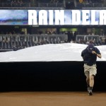 San Diego Padres grounds crew members roll out a tarp during a rain delayed baseball game against the Arizona Diamondbacks in San Diego, Tuesday, Sept. 20, 2016. (AP Photo/Chris Carlson)
