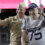Pearl Harbor survivor Lauren Bruner, right, stands with Naval officer Scott Payne while honoring Pearl harbor during halftime of an NCAA college football game between Arizona and Hawaii, Saturday, Sept. 17, 2016, in Tucson, Ariz. (AP Photo/Rick Scuteri)