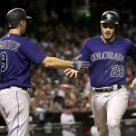 Colorado Rockies Nolan Arenado (28) is greeted by teammate DJ LeMahieu (9) after scoring on a two RBI double by teammate Carlos Gonzalez against the Arizona Diamondbacks during the fifth inning of a baseball game, Monday, Sept. 12, 2016, in Phoenix. (AP Photo/Matt York)