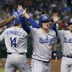 Los Angeles Dodgers' Enrique Hernandez (14), Joc Pederson, center, and Austin Barnes (15) celebrate after scoring against the Arizona Diamondbacks on a pinch-hit double by teammate Adrian Gonzales during the sixth inning of a baseball game, Sunday, Sept. 18, 2016, in Phoenix. (AP Photo/Ralph Freso)