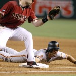 San Francisco Giants' Angel Pagan, right, slides safely back to first base under the late tag of Arizona Diamondbacks' Paul Goldschmidt on a snap throw from Diamondbacks catcher Welington Castillo during the sixth inning of a baseball game, Sunday, Sept. 11, 2016, in Phoenix. (AP Photo/Ralph Freso)